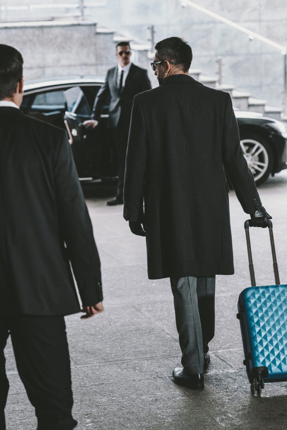businessman-going-with-blue-travel-bag-to-car-e1631423638746
